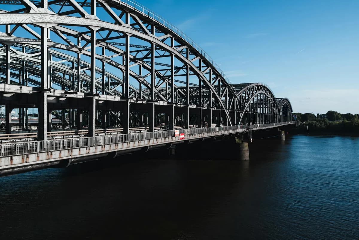 A captivating view down the tracks of an industrial steel railway bridge.