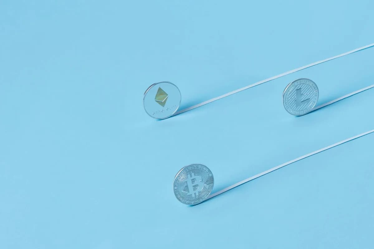 Minimalist image of Bitcoin, Ethereum, and Litecoin coins on a baby blue background.