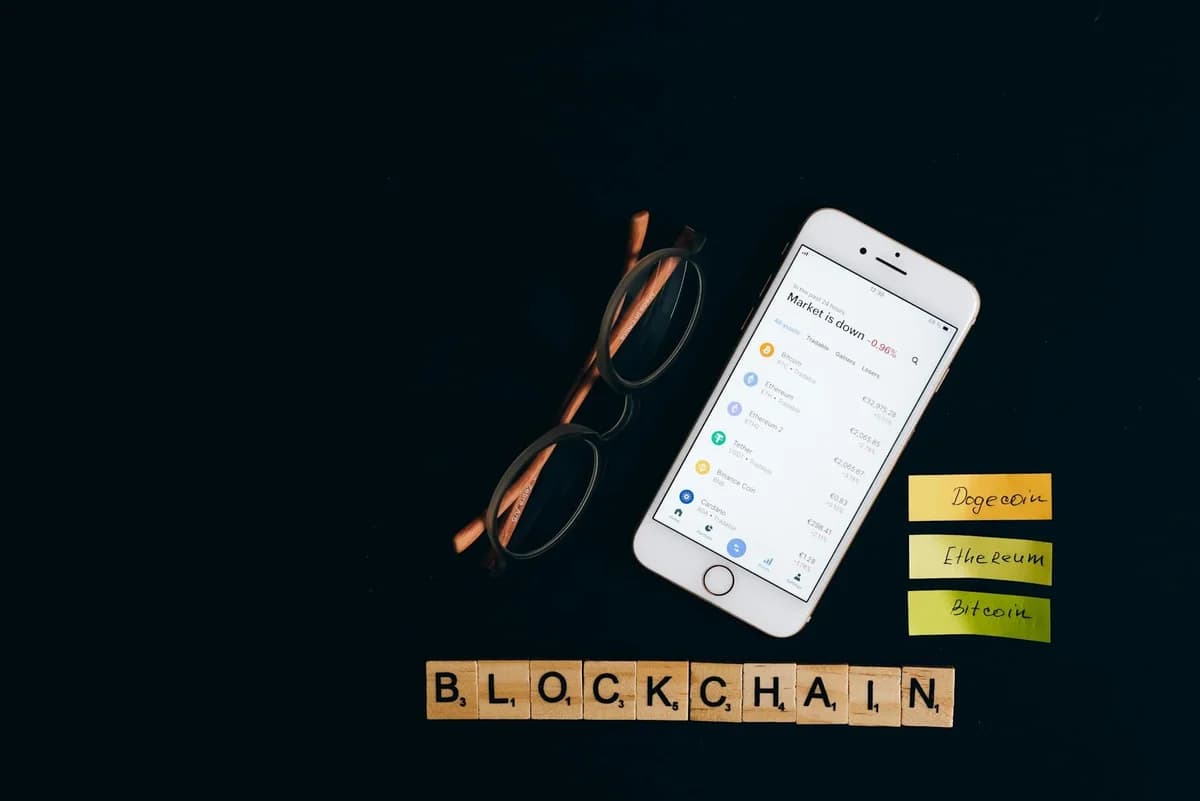 Close-up of a smartphone showing a blockchain app screen held by a hand.