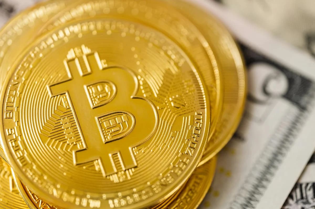 Close-up of Bitcoin cryptocurrency coins with a digital market chart background, symbolizing finance and technology trends.
