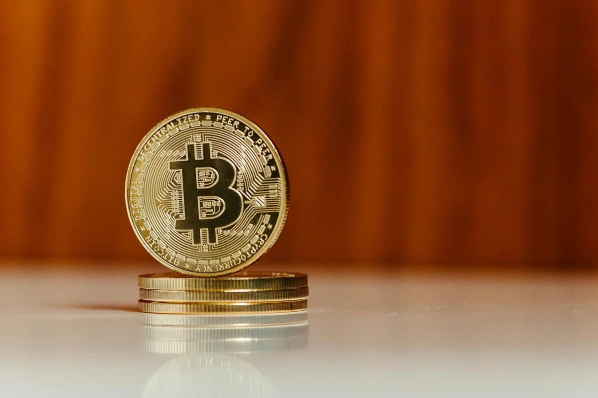 Close-up of a Bitcoin gold coin on a reflective surface, perfect for financial themes.
