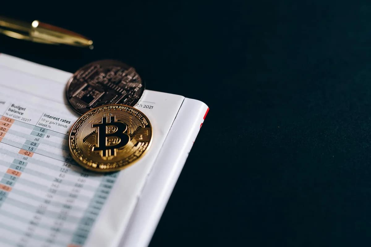 Close-up of Bitcoin coins on a financial report on a dark surface.
