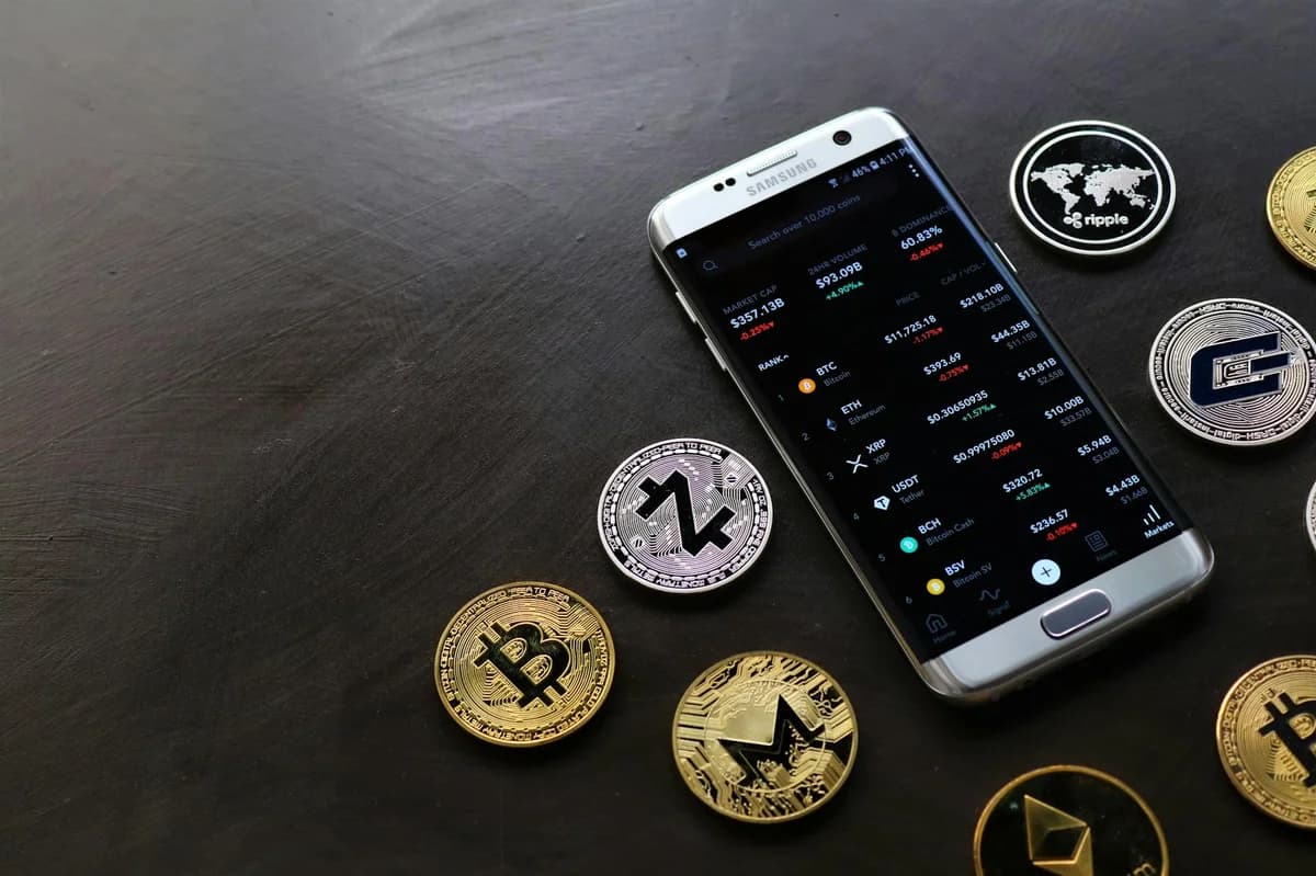 Close-up of a Bitcoin coin placed on financial charts with a pen, symbolizing cryptocurrency and economic analysis.