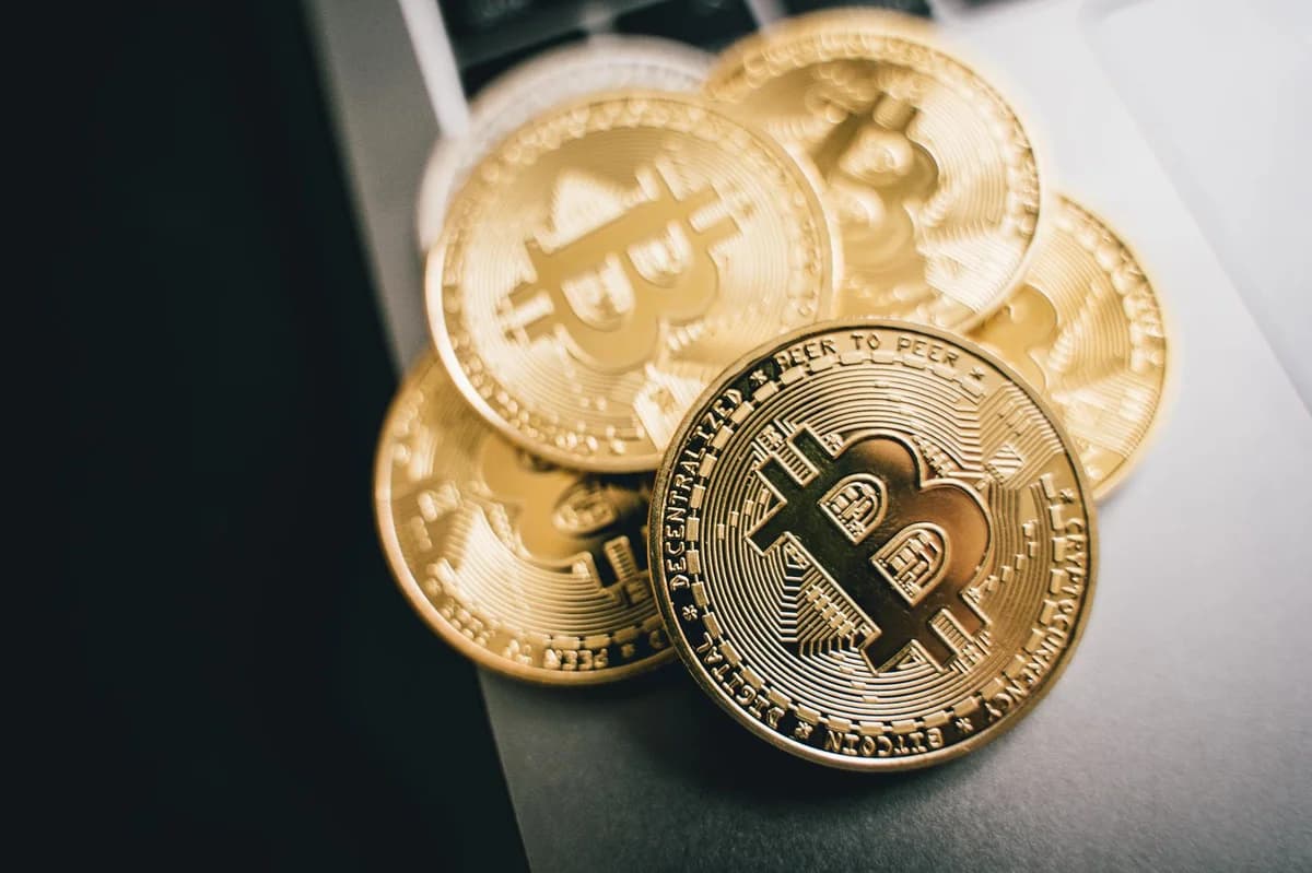Close-up of golden Bitcoin coins on a laptop keyboard, symbolizing cryptocurrency investment.