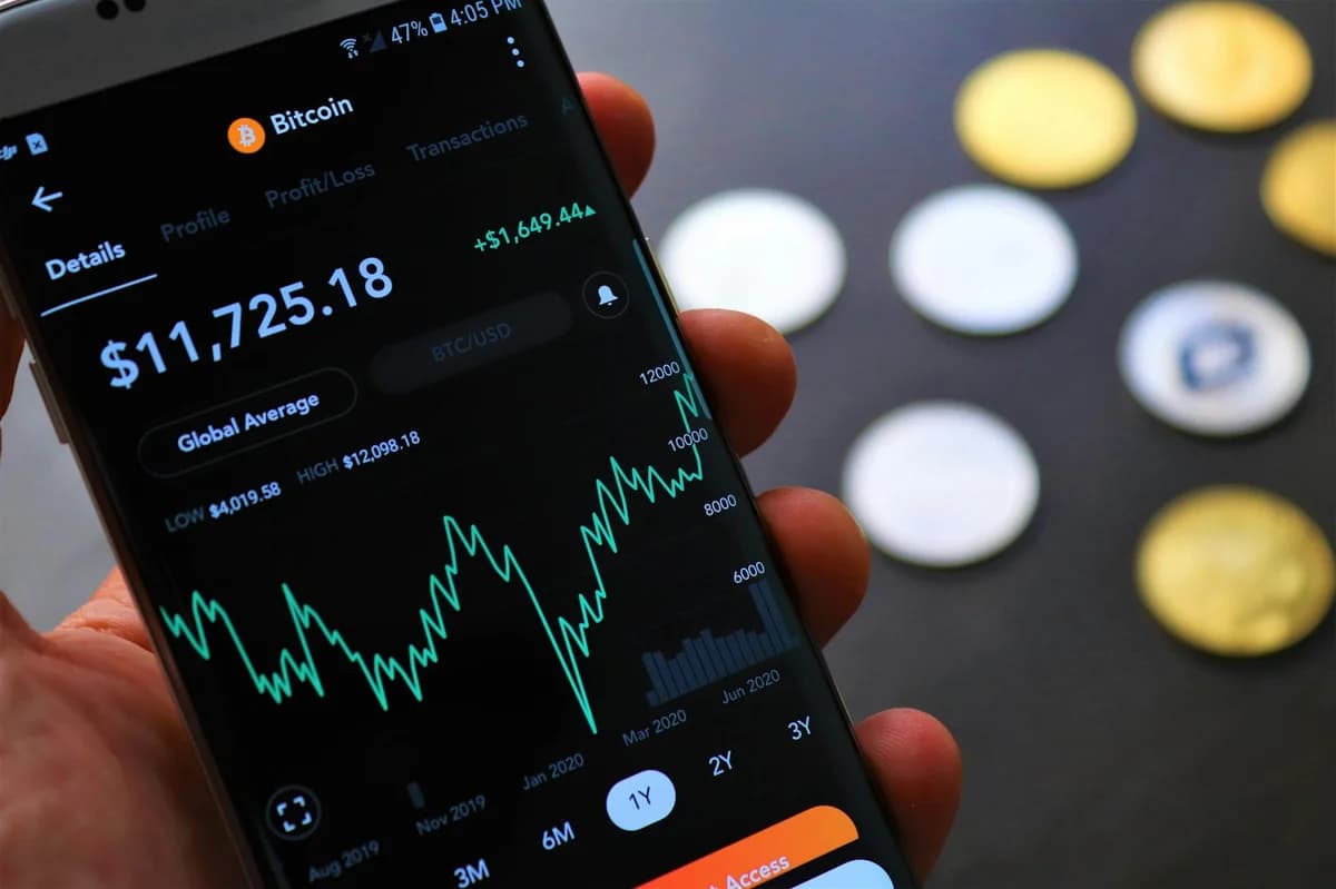Close-up of Bitcoin and Ethereum coins placed on a keyboard, with market charts in the background.