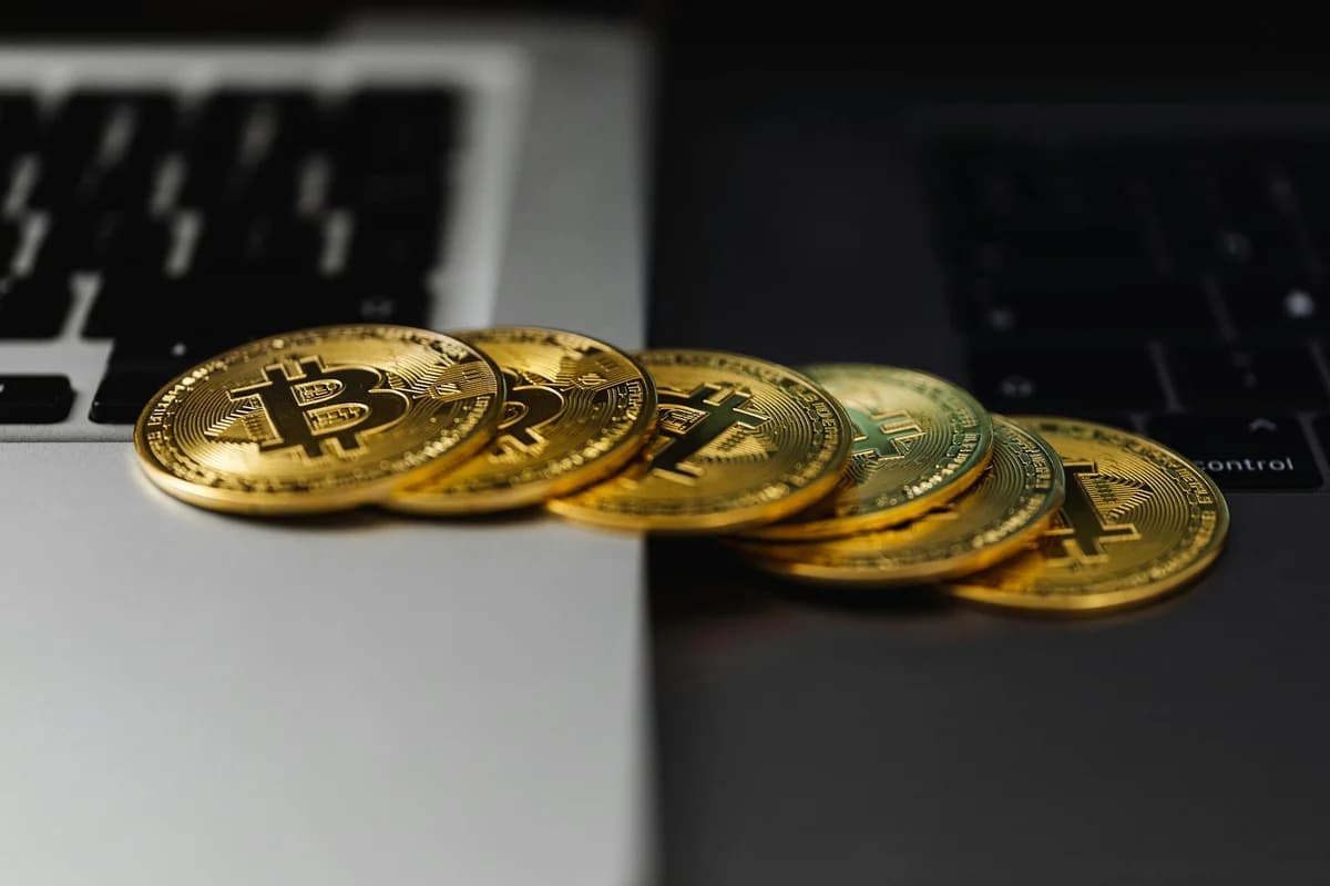 Close-up of Bitcoin coins on a financial report on a dark surface.