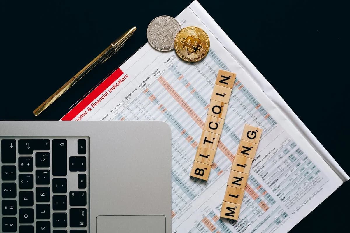 A visual representation of bitcoin mining with smartphone and blockchain concept using Scrabble pieces.