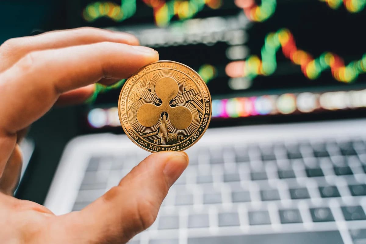Five cryptocurrency coins displayed on a smartphone with Coinbase app open.