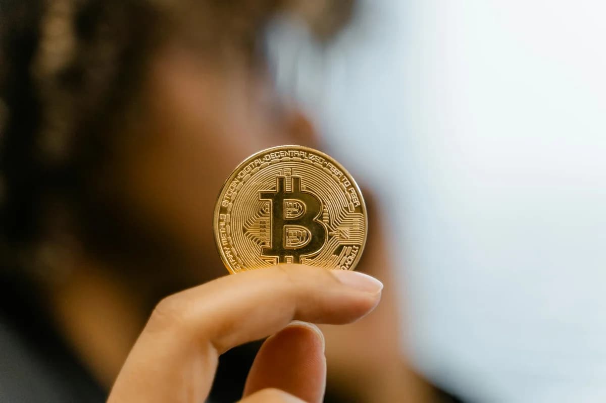 Hand holding a card near a laptop displaying blockchain connection screen.