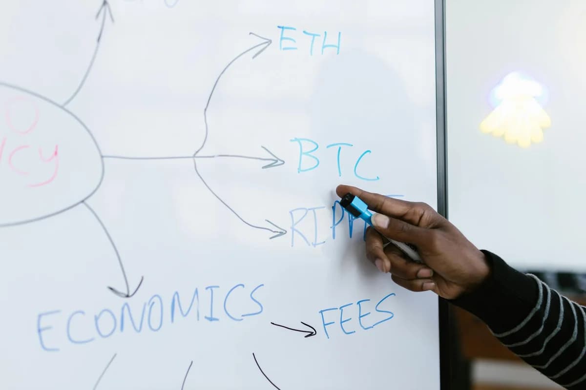 A laptop displays a blockchain screen next to a math textbook, symbolizing digital finance and education.