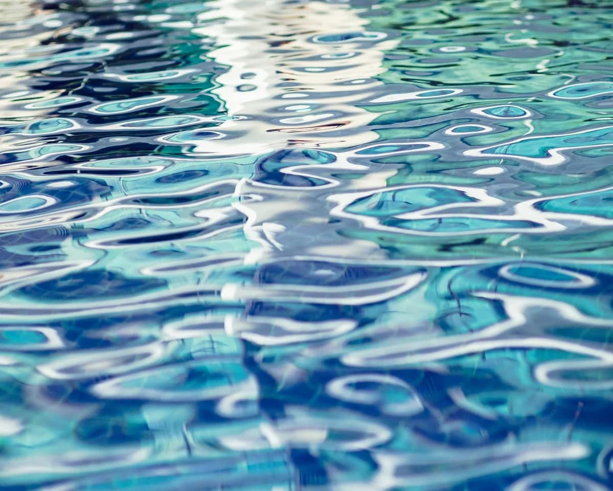 Close-up of turquoise rippled water surface in a tranquil swimming pool.