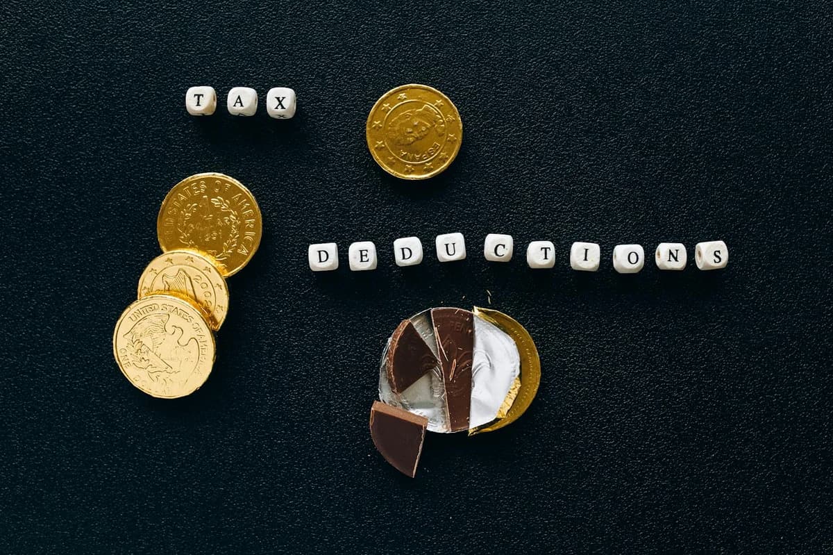 Top view of white vintage light box with TAXES inscription placed on stack of USA dollar bills on white surface