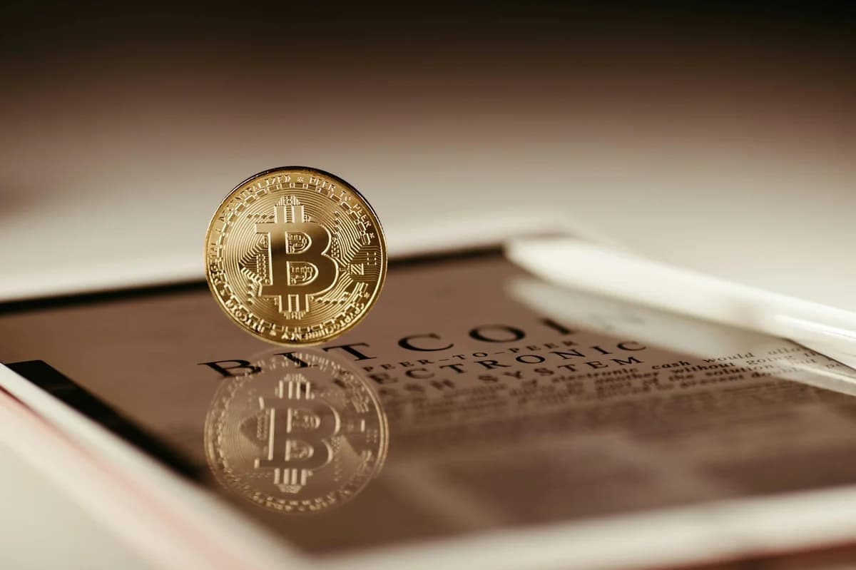 A floating Bitcoin reflecting on a glossy surface symbolizing cryptocurrency trading.