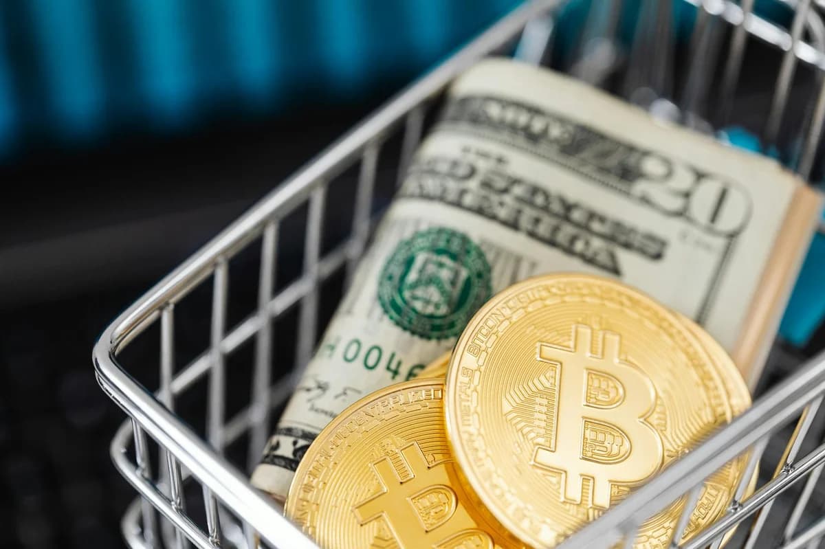Smartphone showing bitcoin price with a physical coin and text representing cryptocurrency investment.