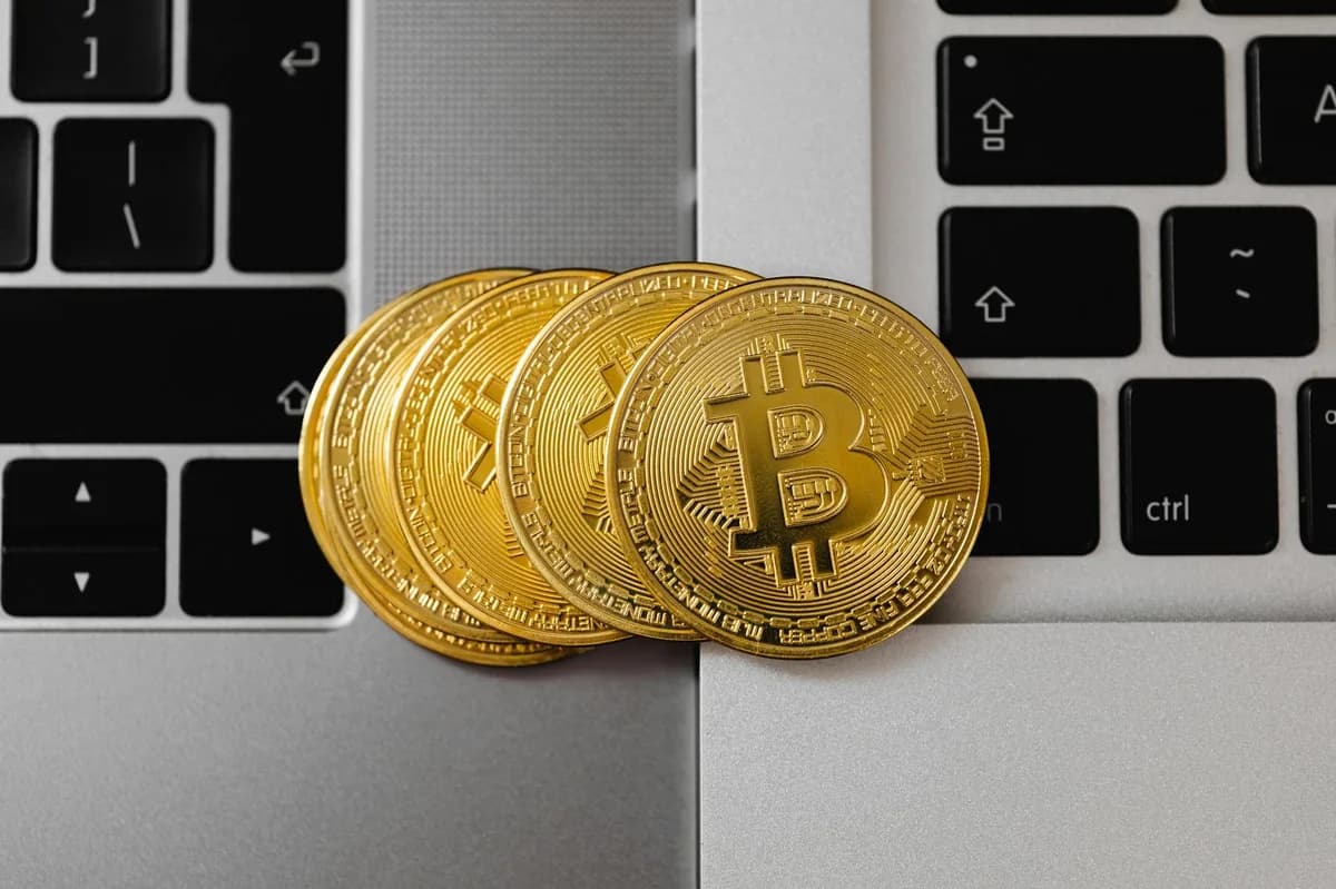 A collection of cryptocurrency coins and a smartphone displaying a digital trading platform.