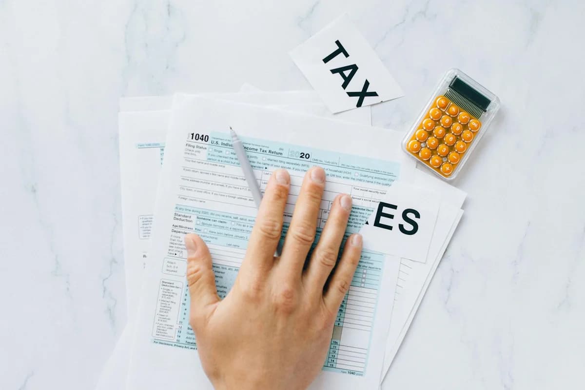 A woman holds U.S. tax documents with a blurred background, implying focus on paperwork.