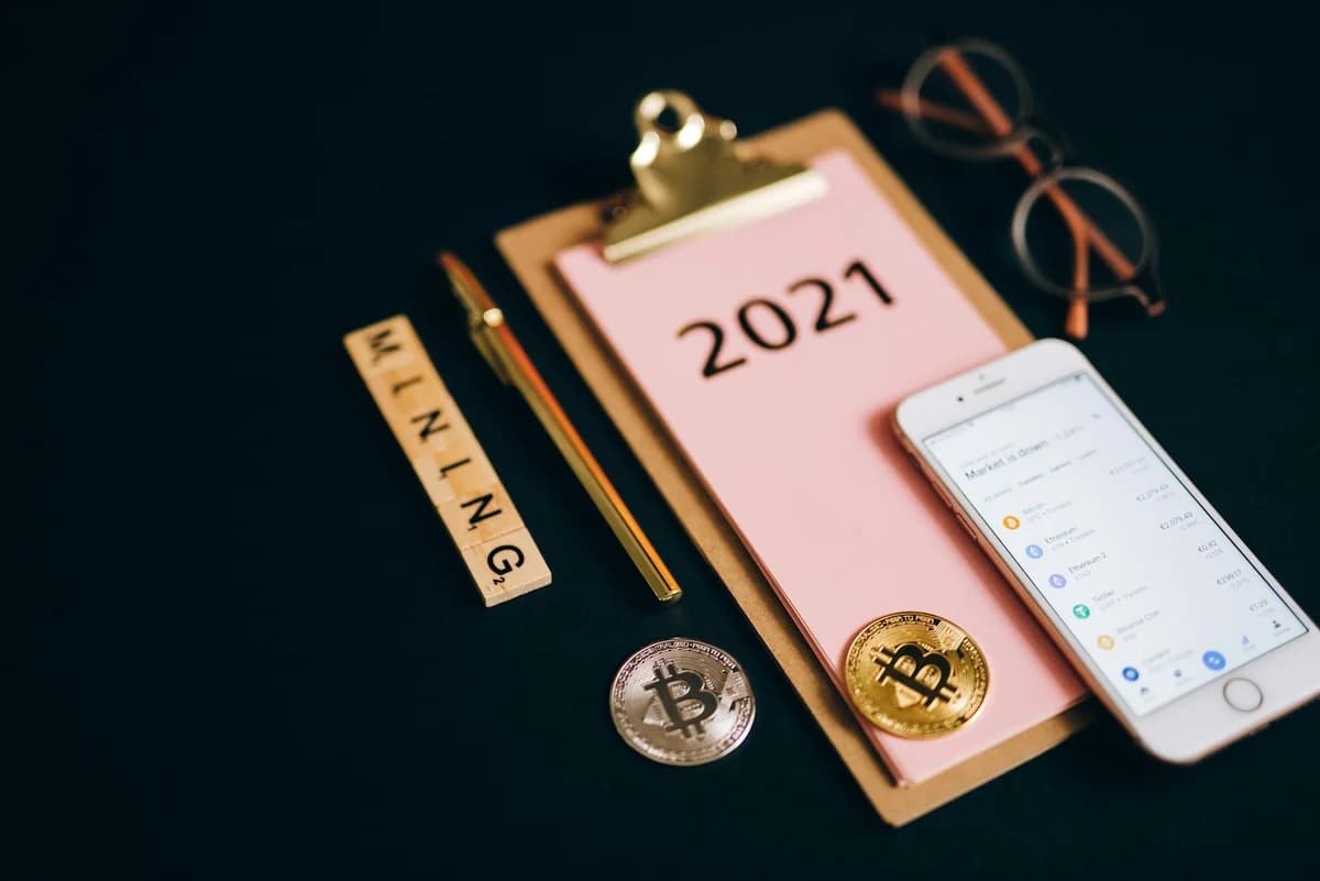 Elegant composition of a leather wallet, smartphone, and watch on a wooden surface.