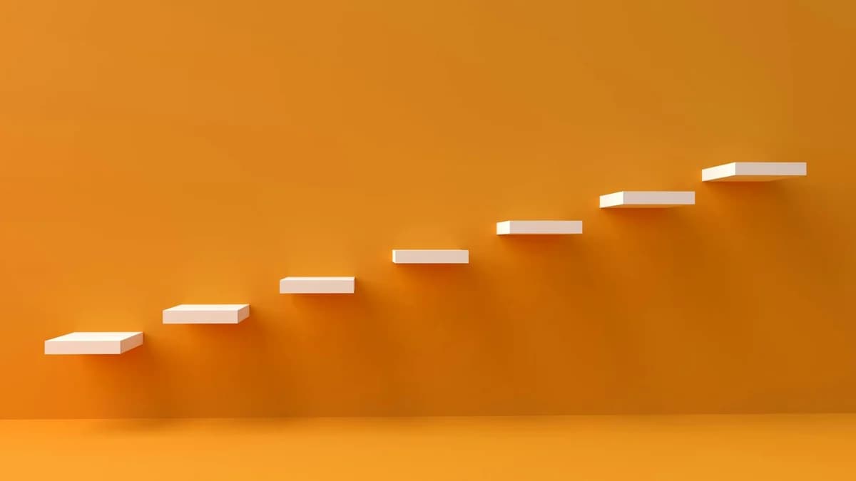White floating steps on vibrant orange wall create a minimalist and conceptual design.