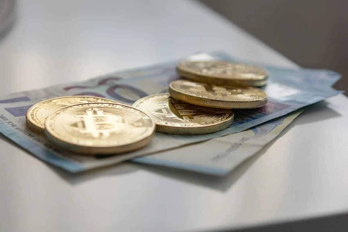Close-up of golden Bitcoin coins with a red background, symbolizing digital currency and blockchain technology.