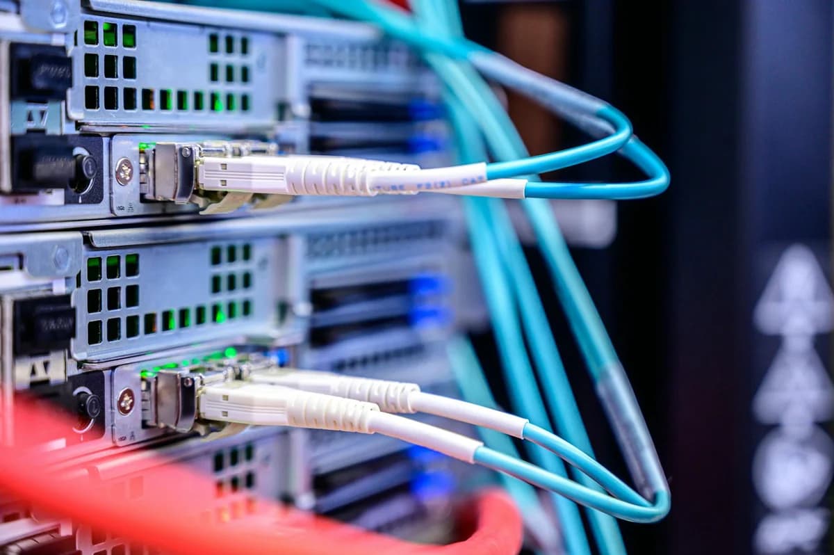 Network switch and blue ethernet cable with white tips connected to system for maintenance