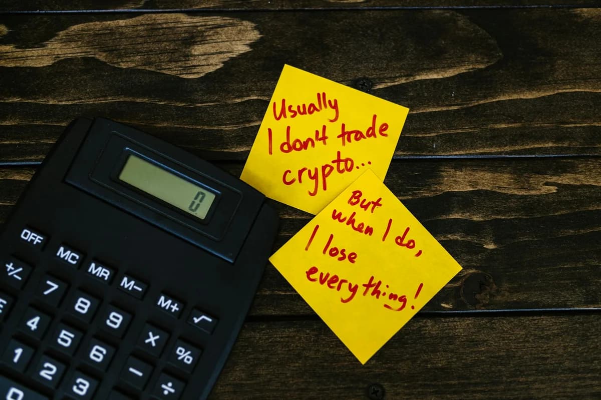 Close-up of a hand holding cryptocurrency coins on keyboard, with a graph display in the background.