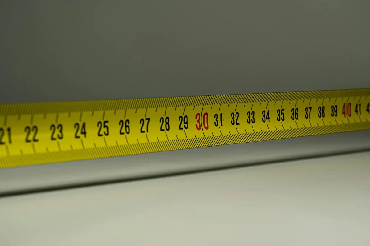 Close-up view of a yellow measuring tape with centimeter marks, emphasizing precision in measurement.
