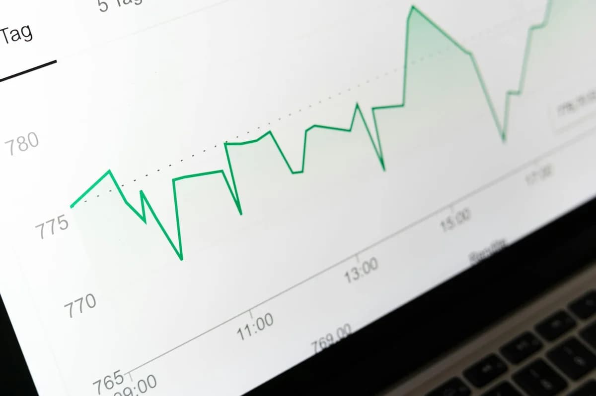Close-up of hands holding a paper with a line graph showing product trends by month during a business meeting.