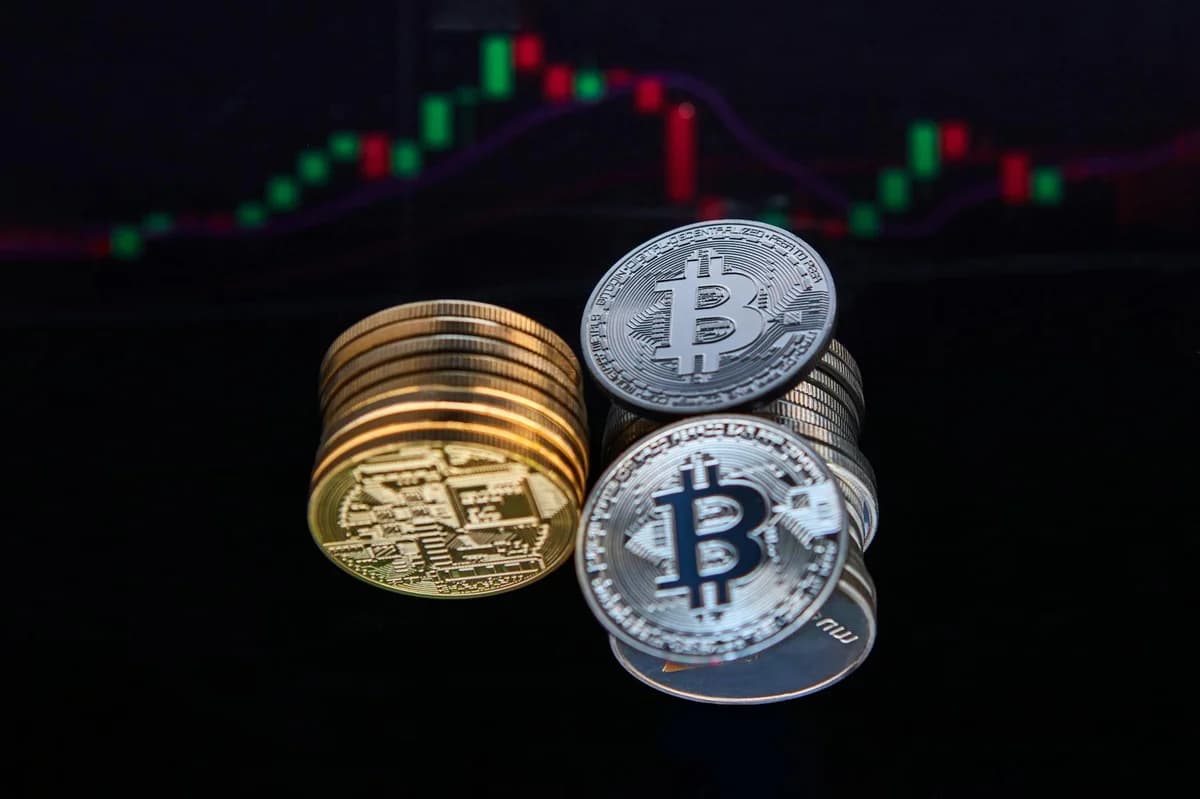 A person pointing at a laptop displaying a cryptocurrency market chart, indicating data analysis.