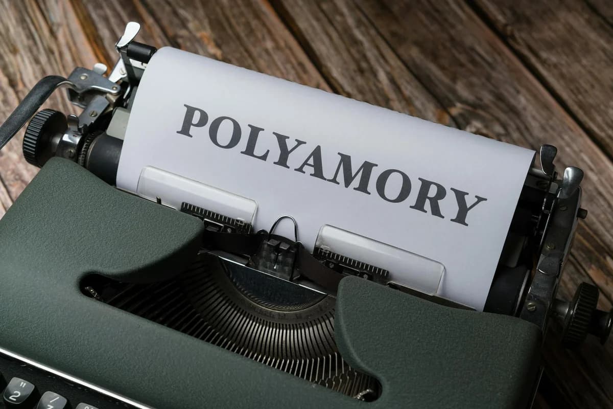 Typewriter with 'POLYAMORY' text on paper, vintage and conceptual image.