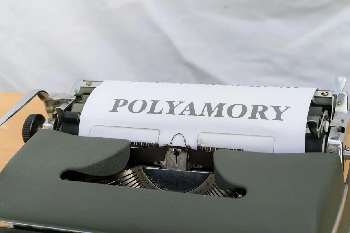 A classic typewriter displaying the word 'Polyamory' on wooden background.