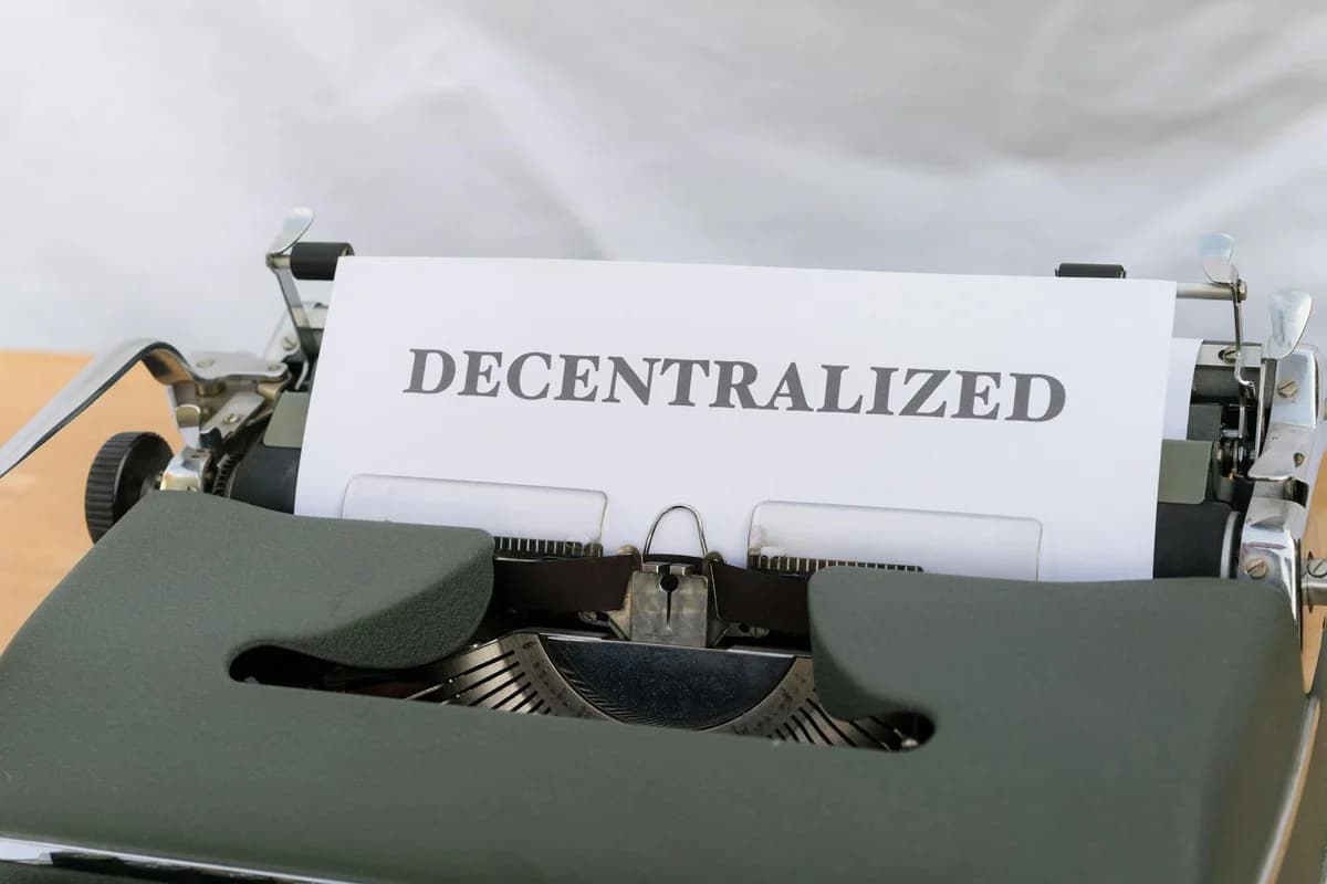 Close-up of a vintage typewriter with paper showing the word 'Decentralized'.