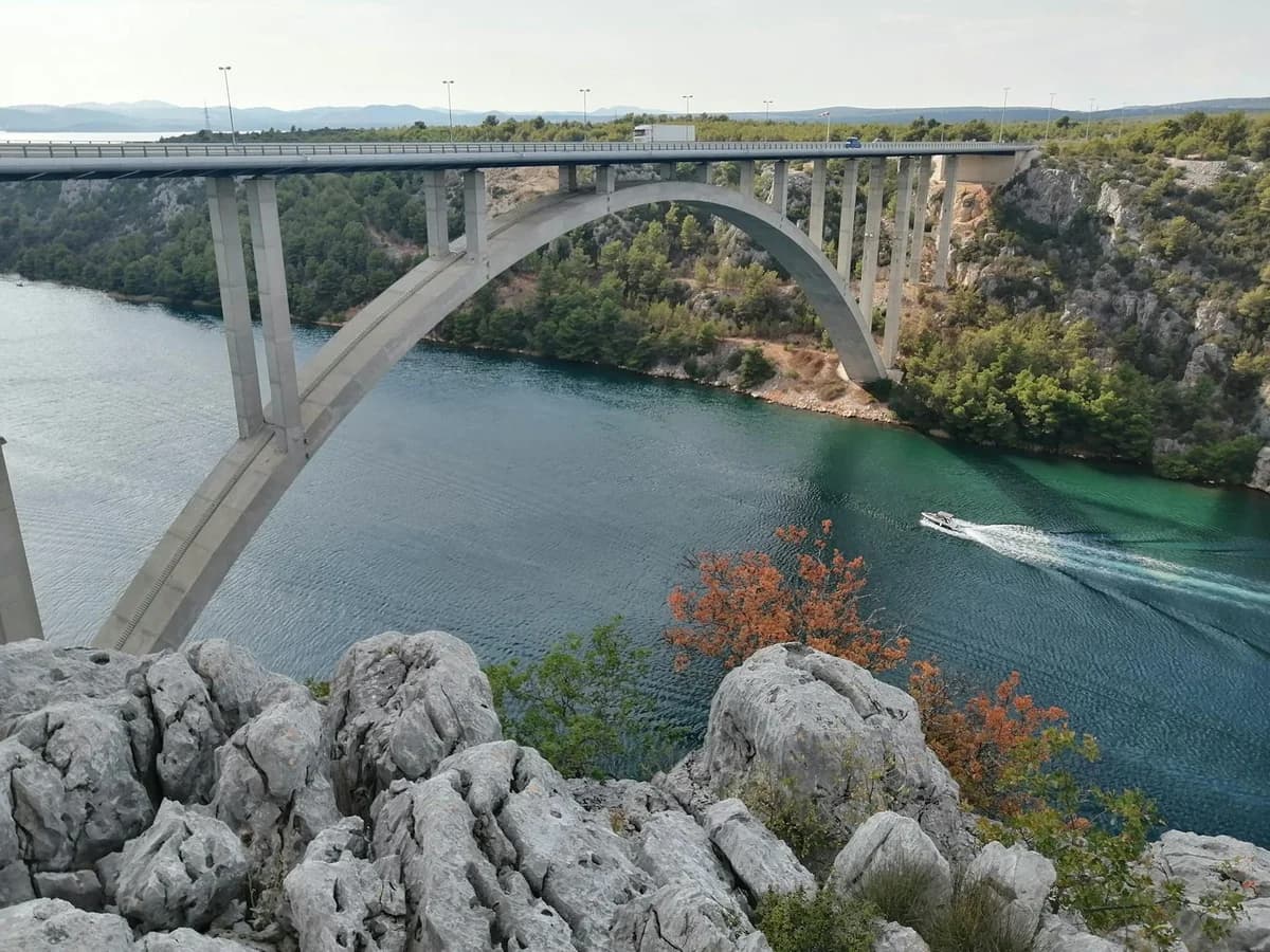 A serene view of the arch bridge spanning the Krka River in Skradin, Croatia.