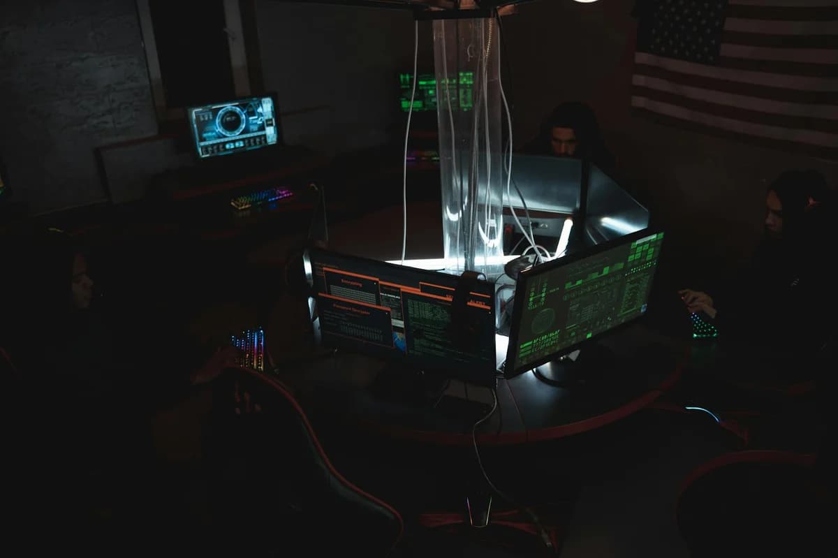 Team of cybersecurity experts collaboratively working on data protection in a dimly lit room filled with computers.