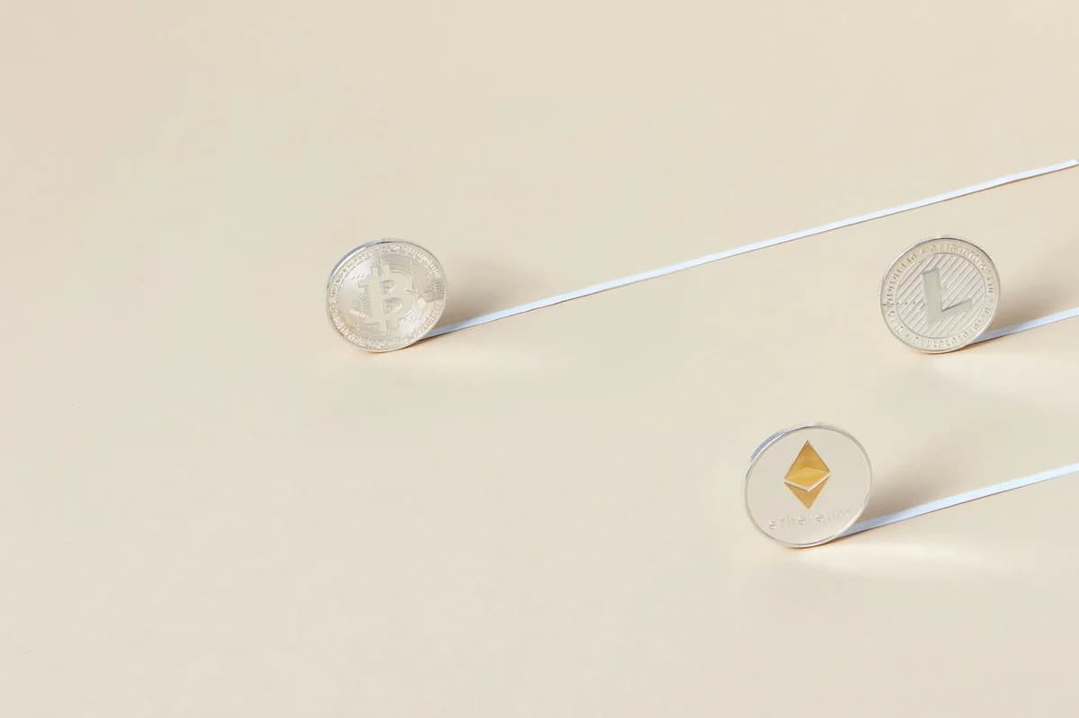 Minimalist studio shot of Bitcoin, Ethereum, and Litecoin coins aligned for a conceptual finance image.