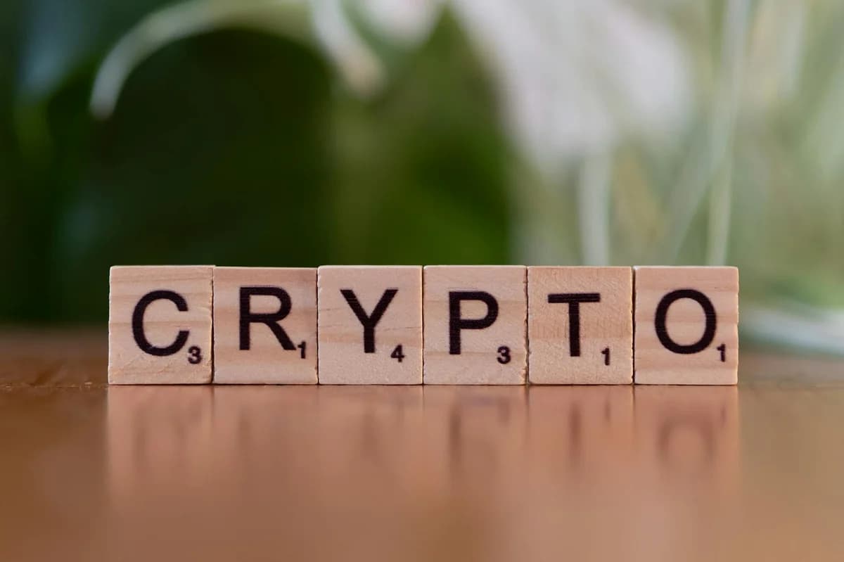 Minimalist display of cryptocurrency coins including Bitcoin and Ethereum on a gray background.