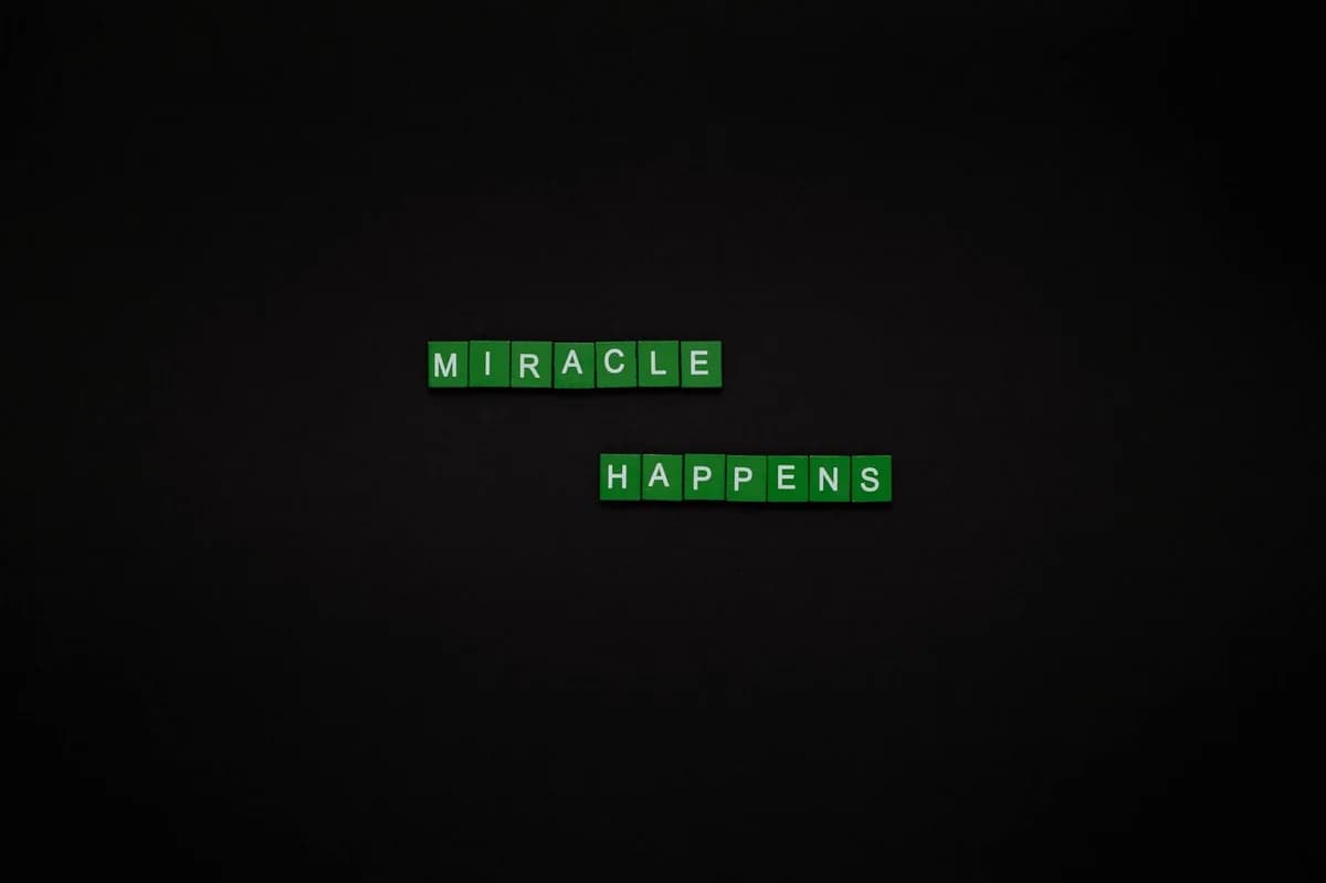 Motivational image featuring the words 'Miracle Happens' using green tiles on a black backdrop.