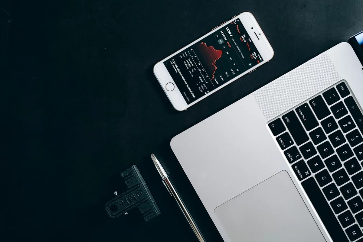Modern workstation setup showcasing laptop, smartphone, and financial data for business use.