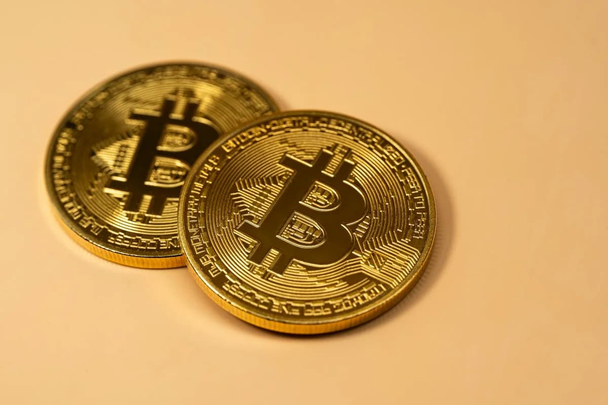 Golden Bitcoin coins placed on a flat surface, symbolizing cryptocurrency and digital finance.