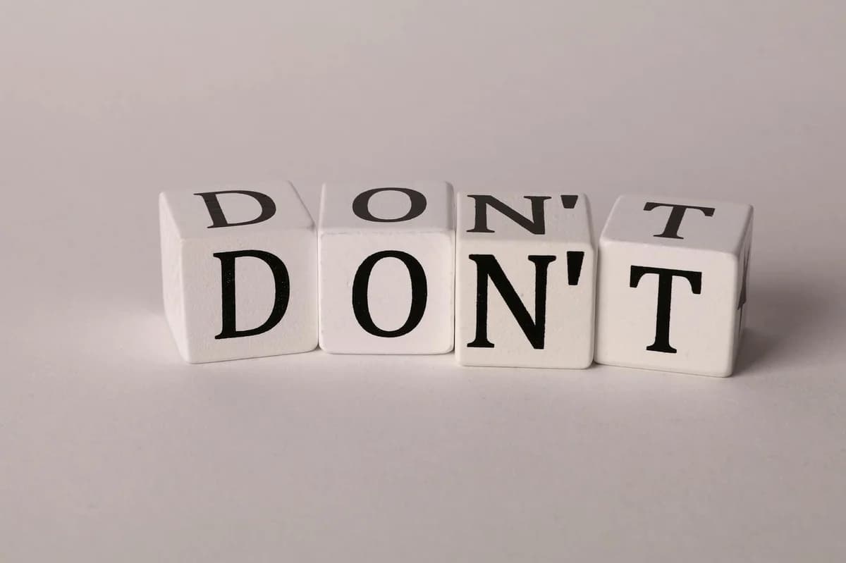 Text cubes spelling 'DON'T' on a clean white background, ideal for concepts of caution or prohibition.