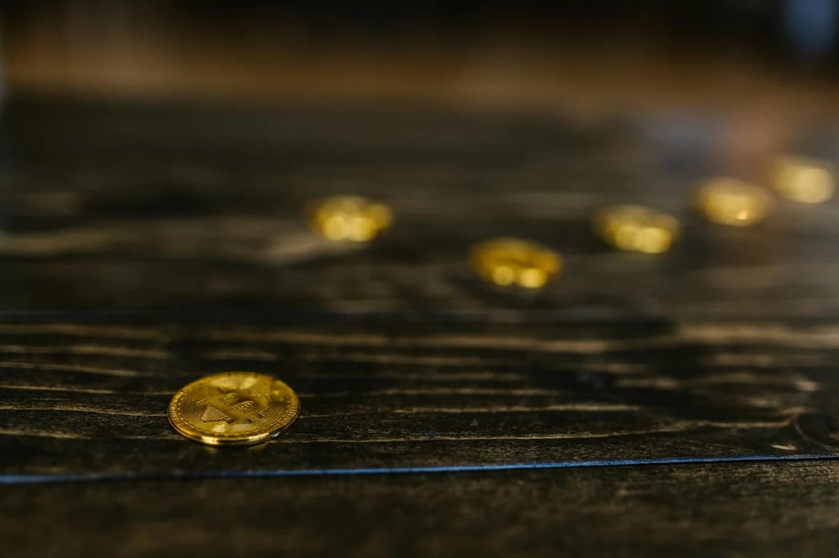 Close-up image of a Bitcoin coin on a reflective surface, highlighting its digital currency aspect.