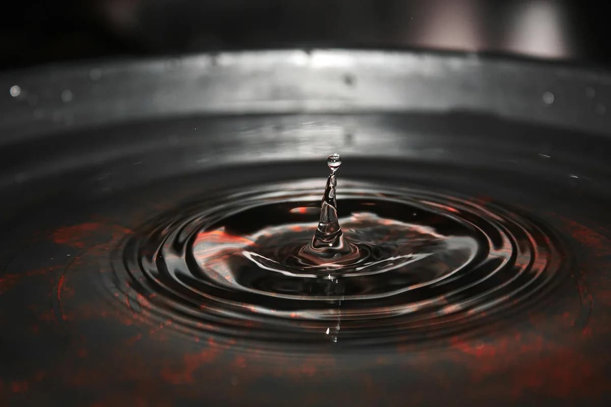 A mesmerizing close-up of a water droplet creating ripples in a pool, shot in Carazinho, Brazil.
