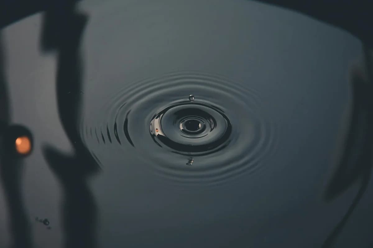 A close-up capture of water droplet creating ripples, showcasing nature's tranquility.