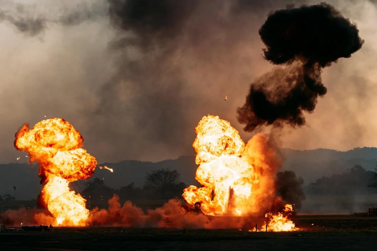 Intense explosion scene with billowing fire and dark smoke against an outdoor landscape.