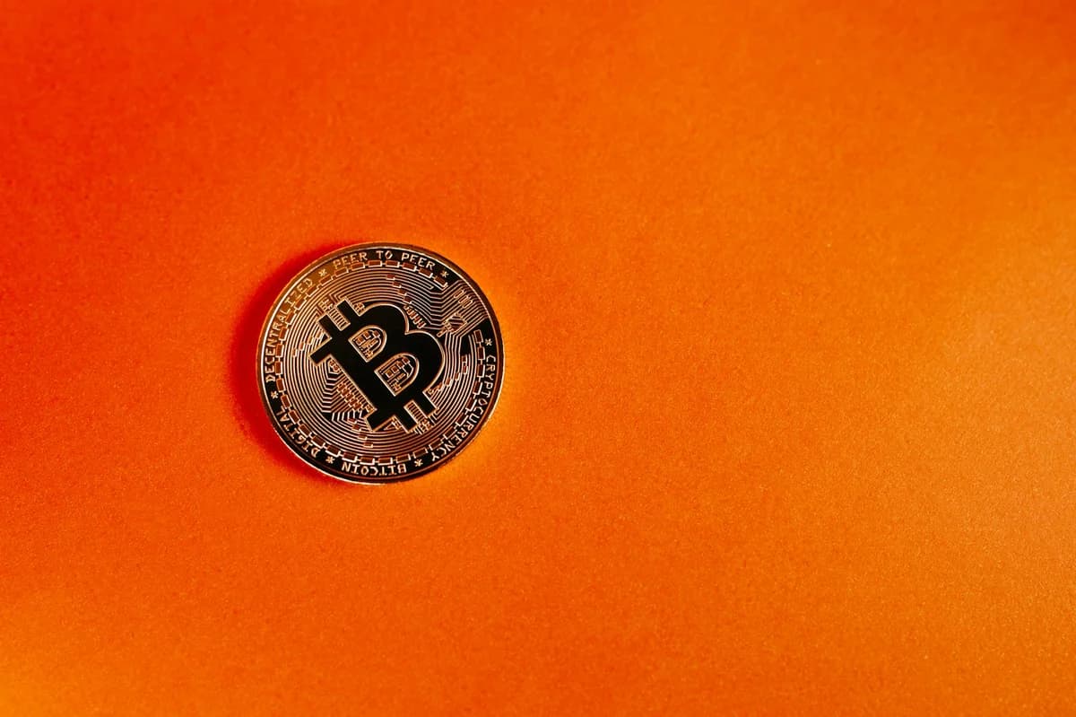 Close-up of various cryptocurrency coins including Bitcoin, EOS, and Litecoin on a colorful background.