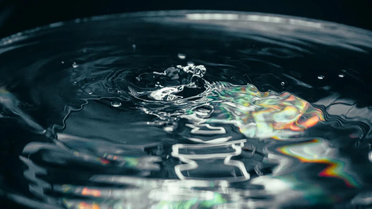 Artistic close-up shot of a water surface with cinematic rainbow reflections, capturing fluid motion.