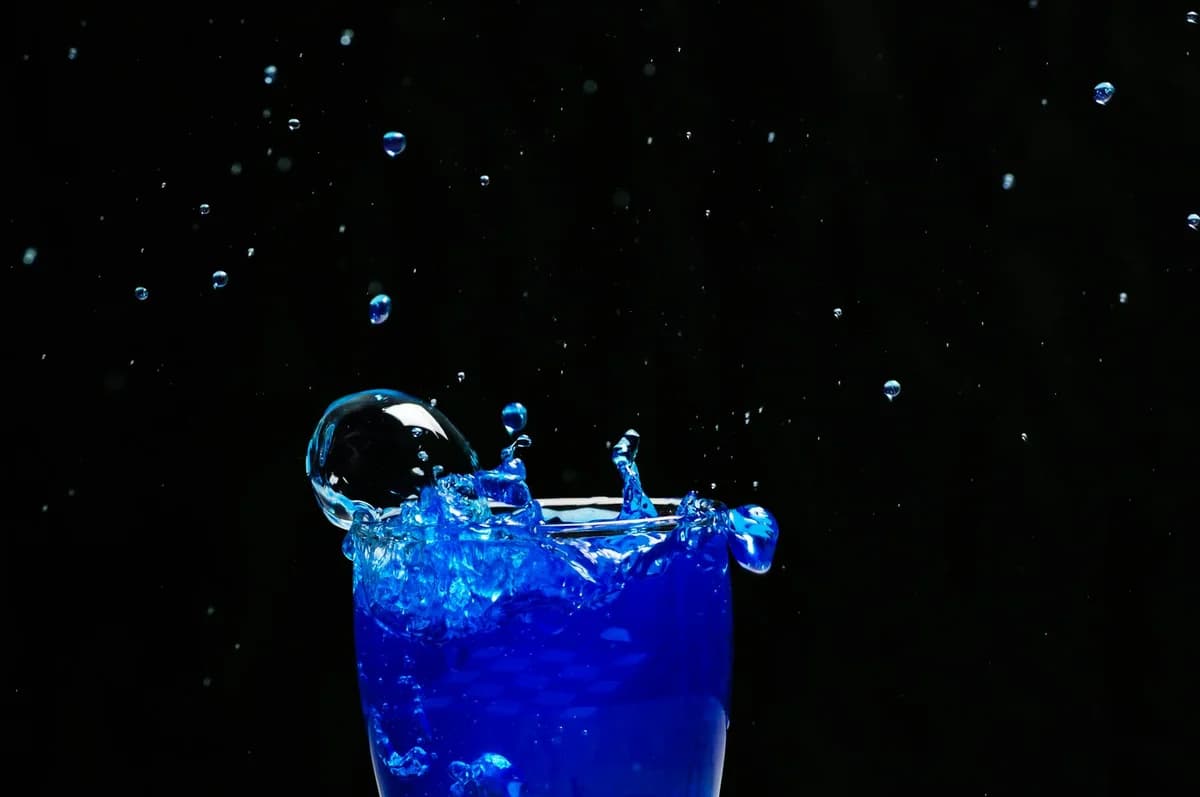 A captivating splash of bright blue liquid against a dark background, showcasing dynamic motion and vibrant energy.