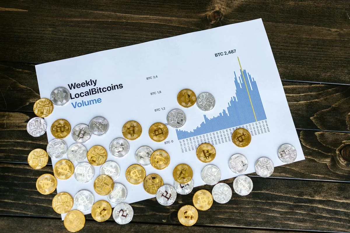 Gold Bitcoin on screen with rising investment chart indicating cryptocurrency growth.