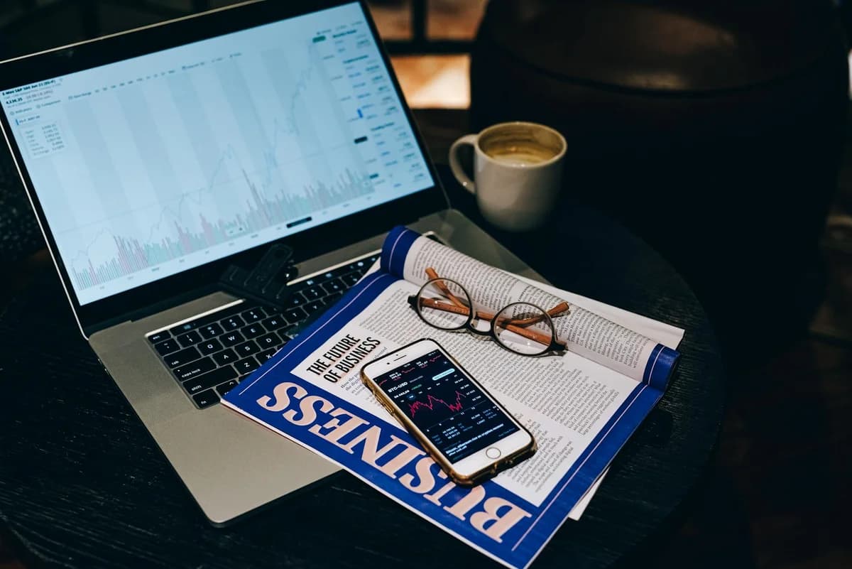 A pair of eyeglasses resting on a financial document and magazine with bold headline "LEADERS" in focus.