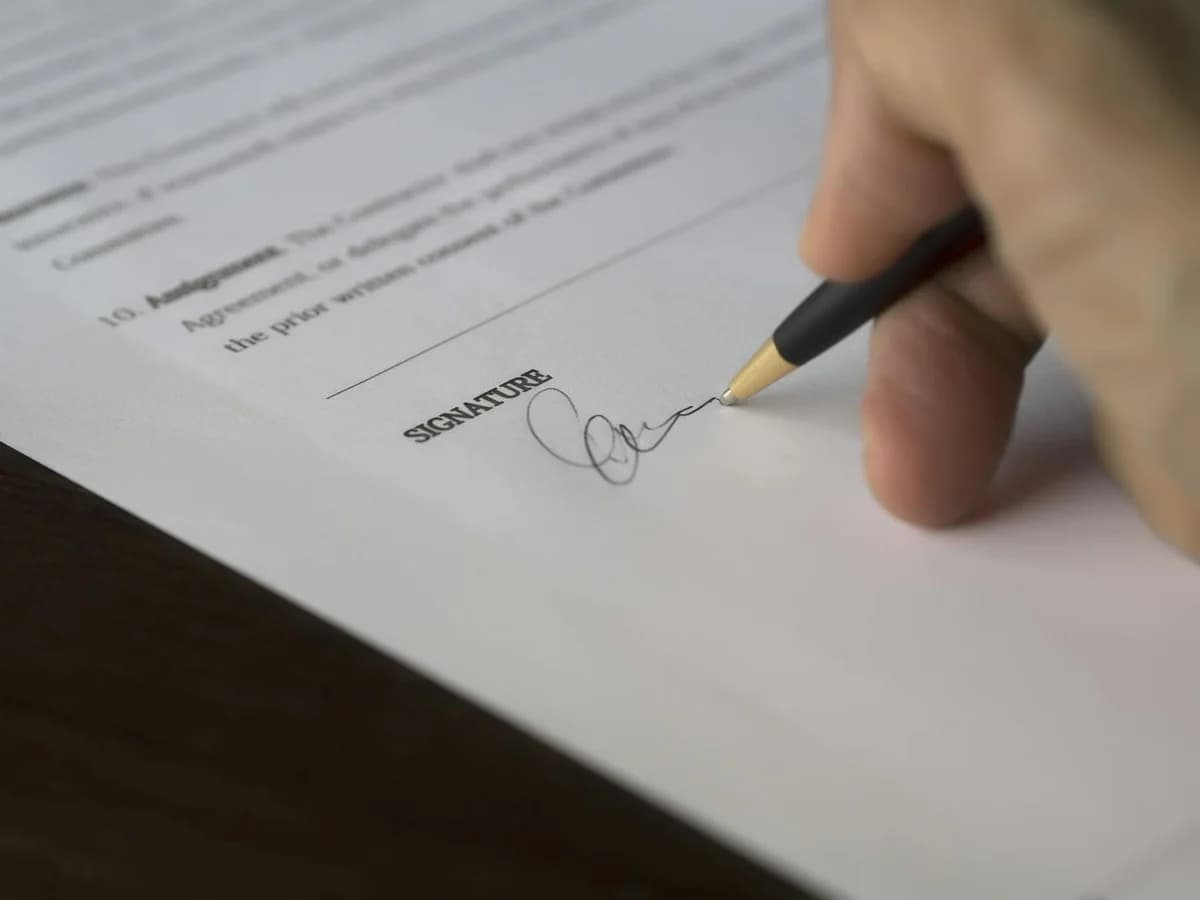 Two people completing a digital transaction with electronic signature on a smartphone screen.