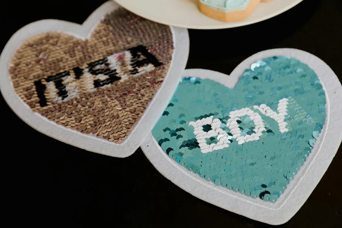 Sequin heart decorations reveal 'It's a Boy' for a gender reveal party.